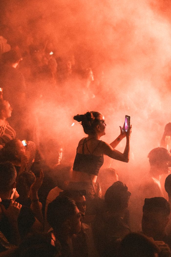 Mastering the First Impression: Your intriguing post title goes here Lively festival scene with a crowd immersed in music and vibrant smoke effects.